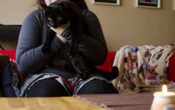 Pia i vardagsrummet med sin katt i famnen. Bilden är anonymiserad.