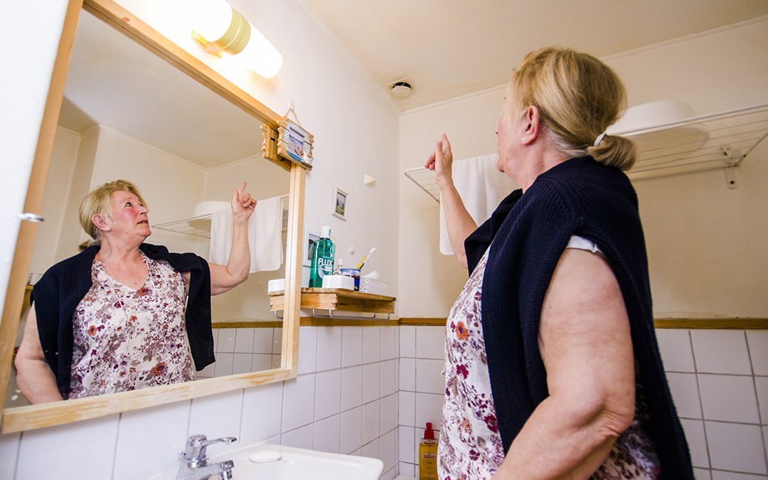 Hyresgästen Inger Sjögren pekar på en badrumsventil i sin lägenhet.