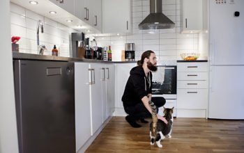 Kim Jonsson med sin katt i det nyrenoverade köket.