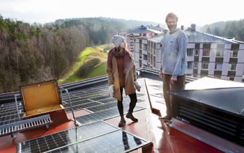 Michelle Wermäng och Zack Norwood inspekterar de nya solpanelerna på niovåningshusets tak.