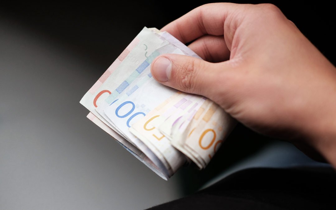 Bunt med sedlar i en hand.