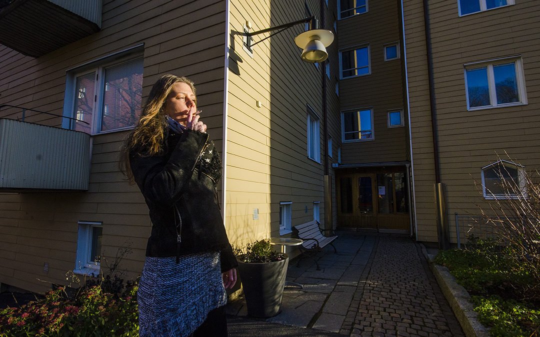 Pia Fridström röker utanför sitt hus.