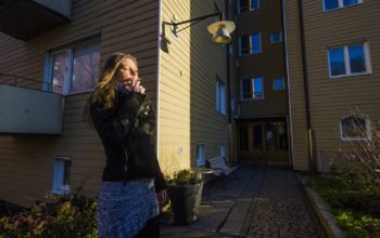Pia Fridström röker utanför sitt hus.