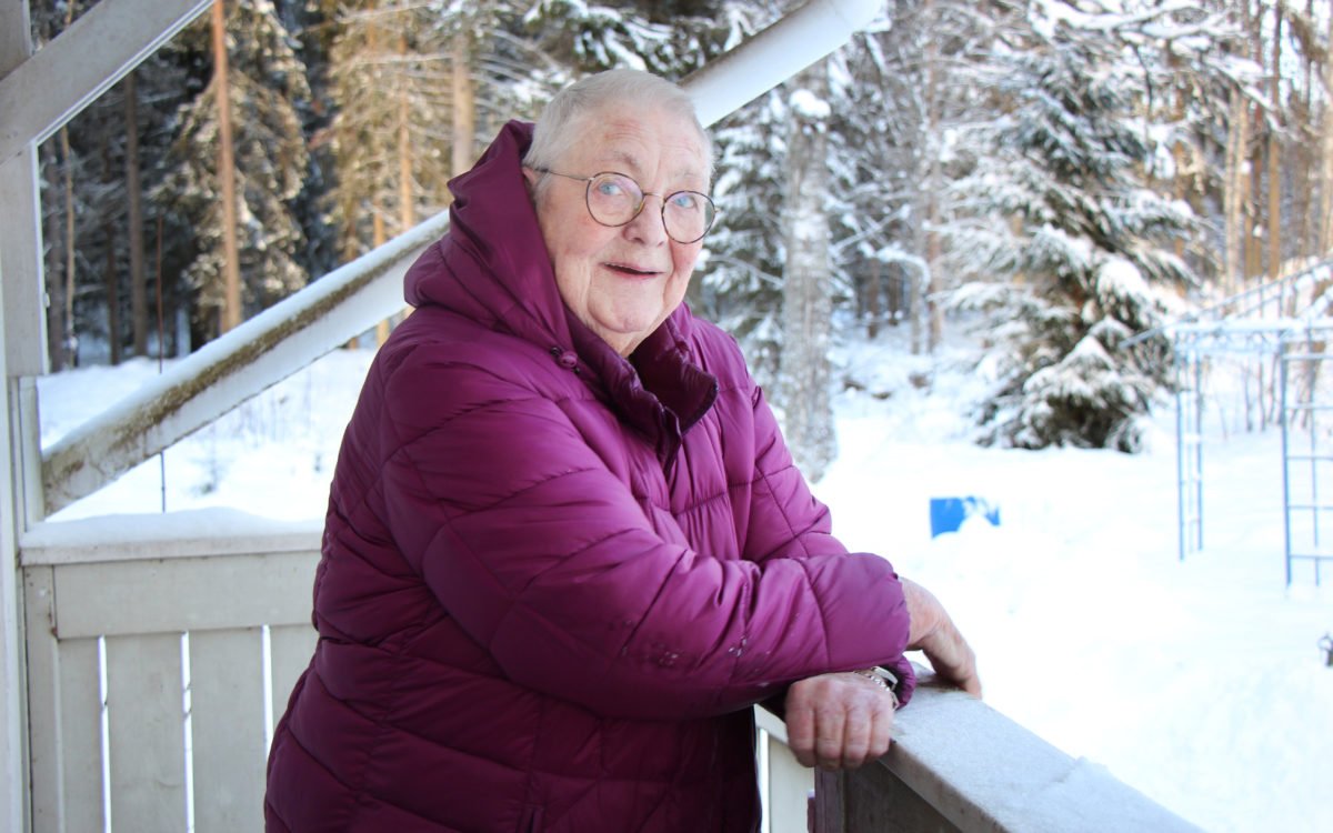 80-åriga Vita Pedersen har problem med att ta sig fram i området eftersom snöplogning och halkbekämpning inte fungerar. På bilden står hon lutad mot sitt trappräcke.