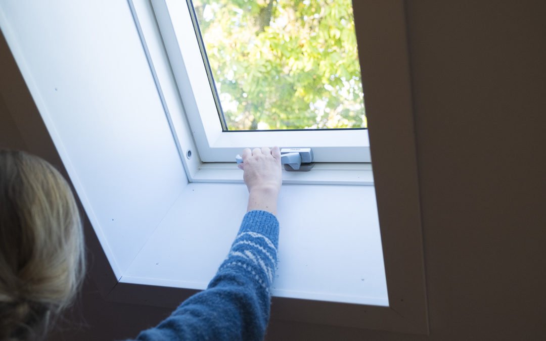 Foto på en person som försöker öppna ett takfönster