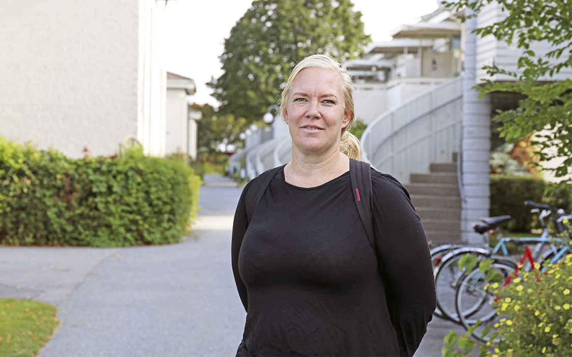 Hanna Hagström står på en gång i bostadsområdet. En trapp skymtar i bakgrunden.