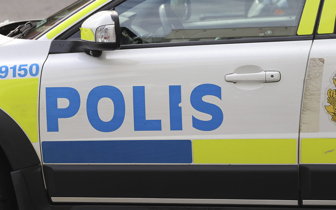 Närbild på en polisbil. Endast delar av bilen syns, dörren med ordet ”Polis”.