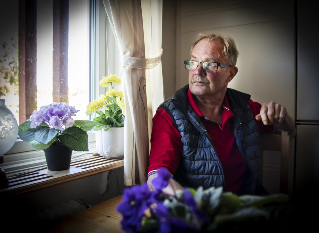 Roger Magnusson sitter vid köksbordet och tittar ut genom fönstret.