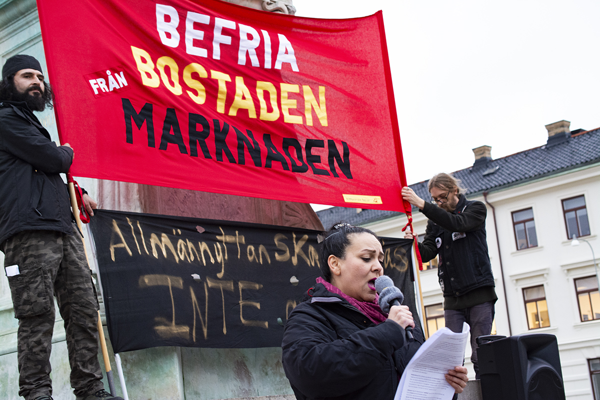 Demonstration mot ombildningar i Göteborg. Mahasti Hashemieh talar framför banderoll med texten Befria bostaden från marknaden.