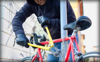 Man stjäl en cykel med hjälp av bultsax