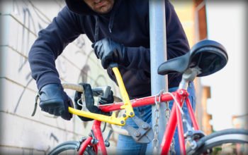 Man stjäl en cykel med hjälp av bultsax