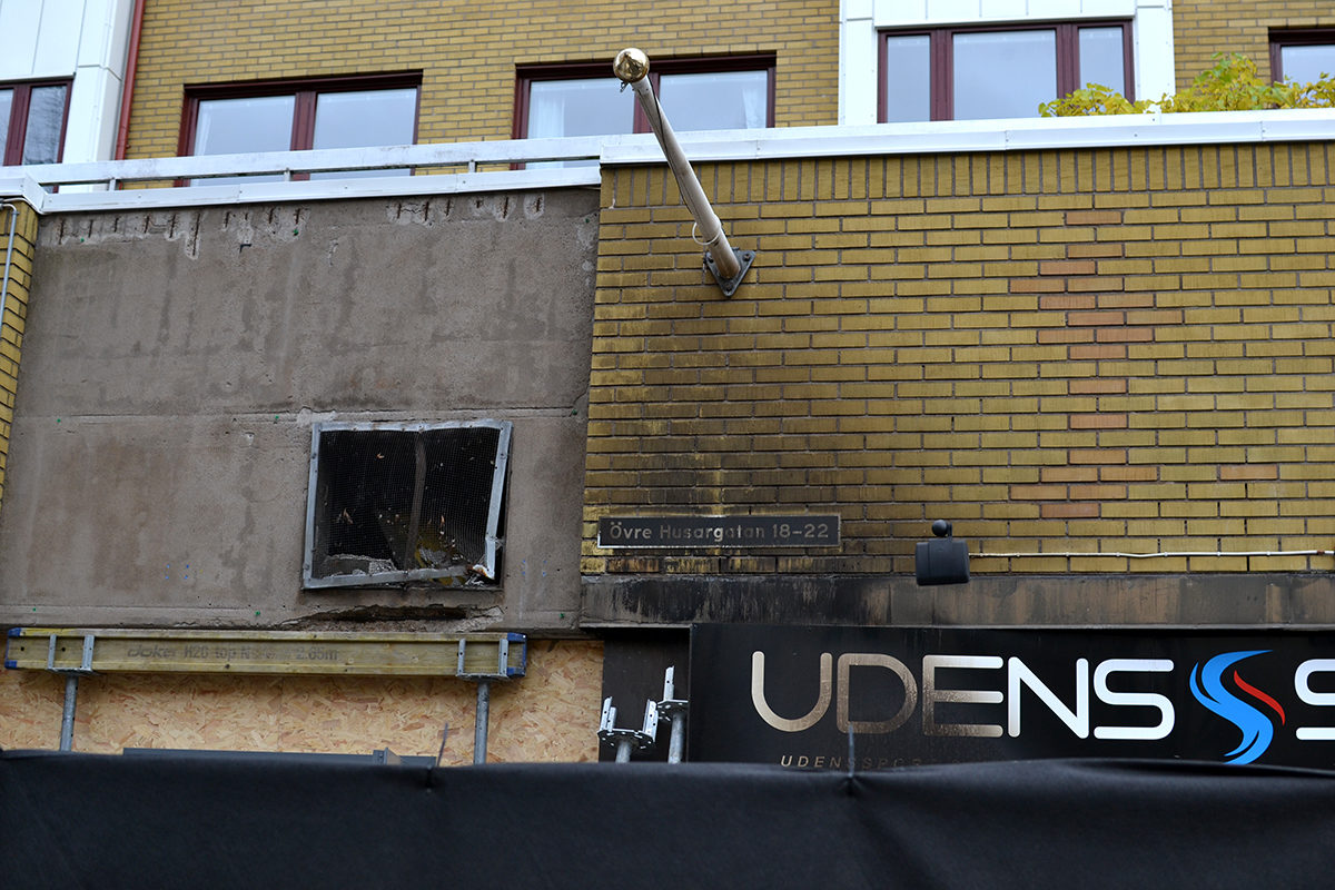 Explosionen på Övre Husargatan, bilden visar gatunamnsskylt samt sotig fasad.