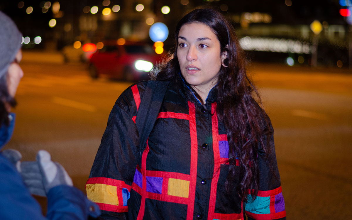 Stämd på rättegångskostnader. En kvinna pratar med en annan kvinna vid en korsning