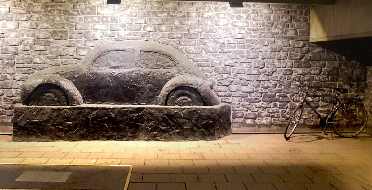 Konstverk i Orrholmsgaraget i Karlstad föreställandes en bil på en vägg. Intill står en cykel parkerad.