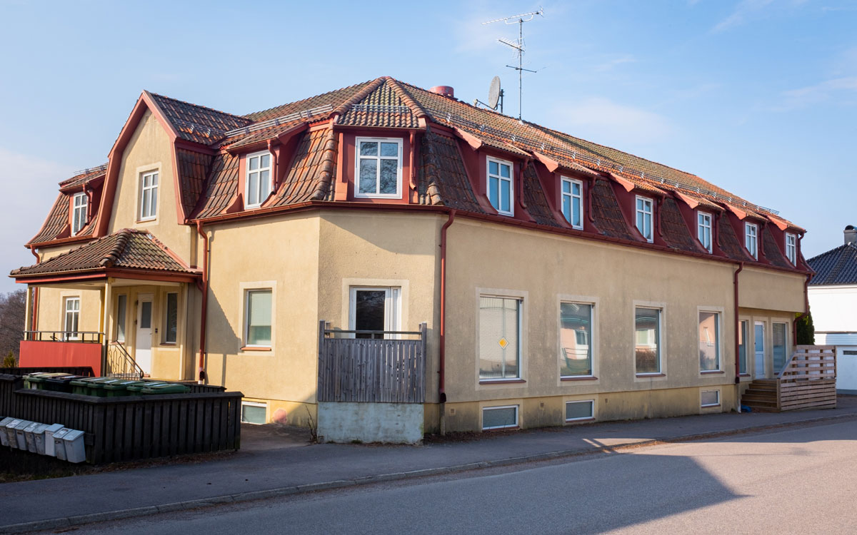 Ett gult bostadshus. Ska säljas på exekutiv auktion.