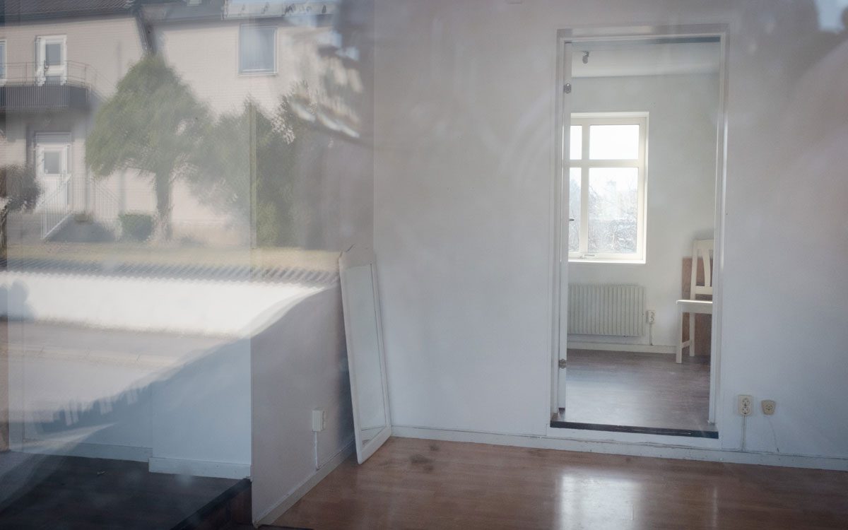 En tom lägenhet sedd utifrån ett fönster.