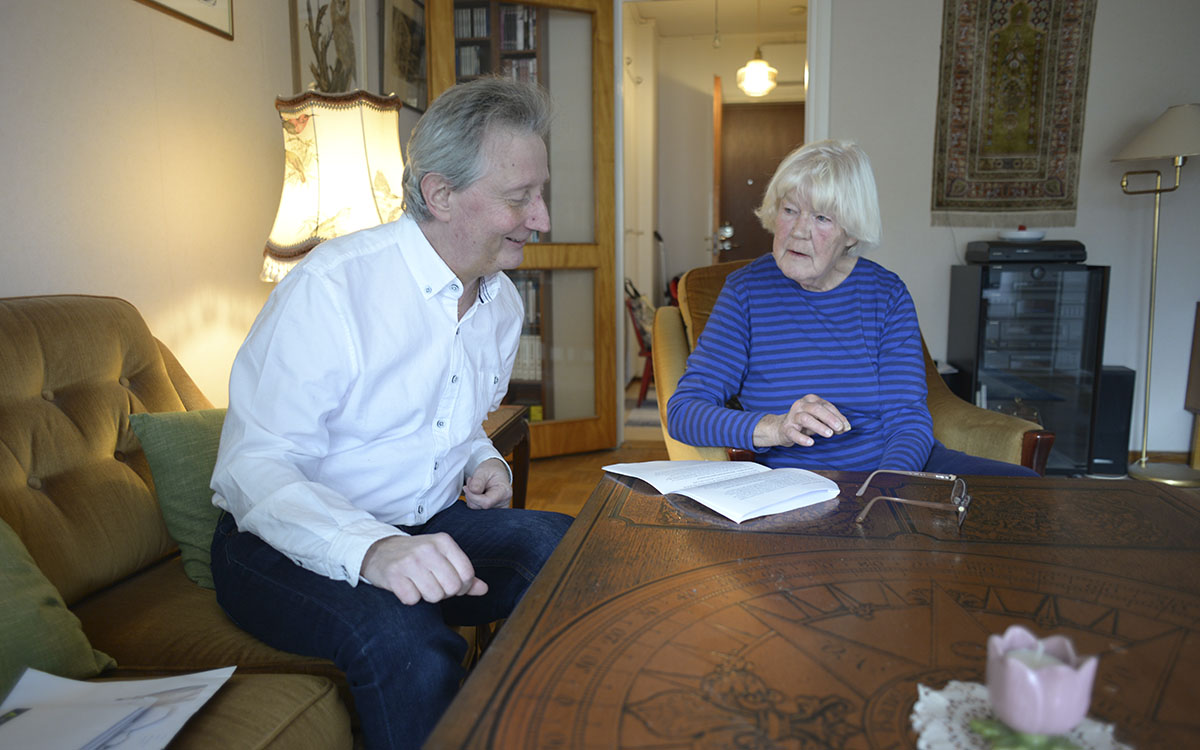 Lars och Anita sitter vid Anitas bord och diskuterar dokument.