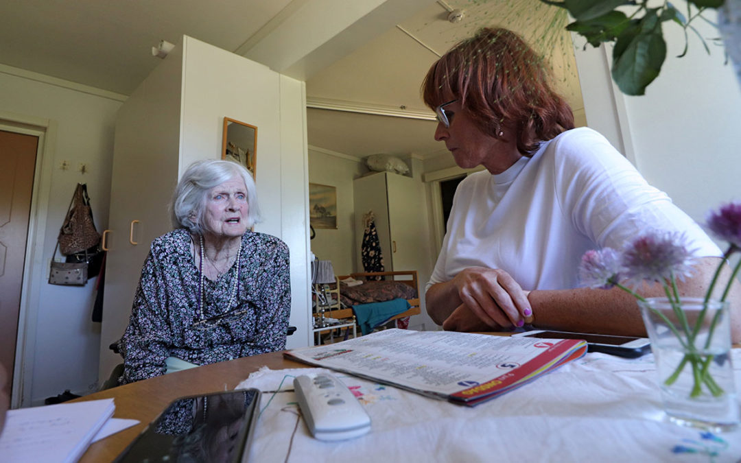 Äldre kvinna pratar med sin dotter på ett äldreboende