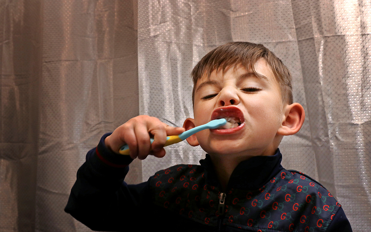 Liten pojke som borstar sina tänder.