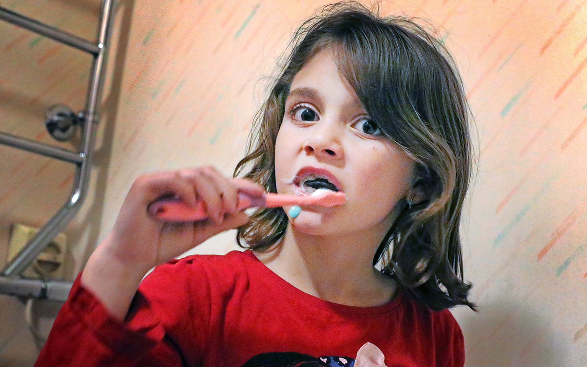 Liten flicka som borstar sina tänder.