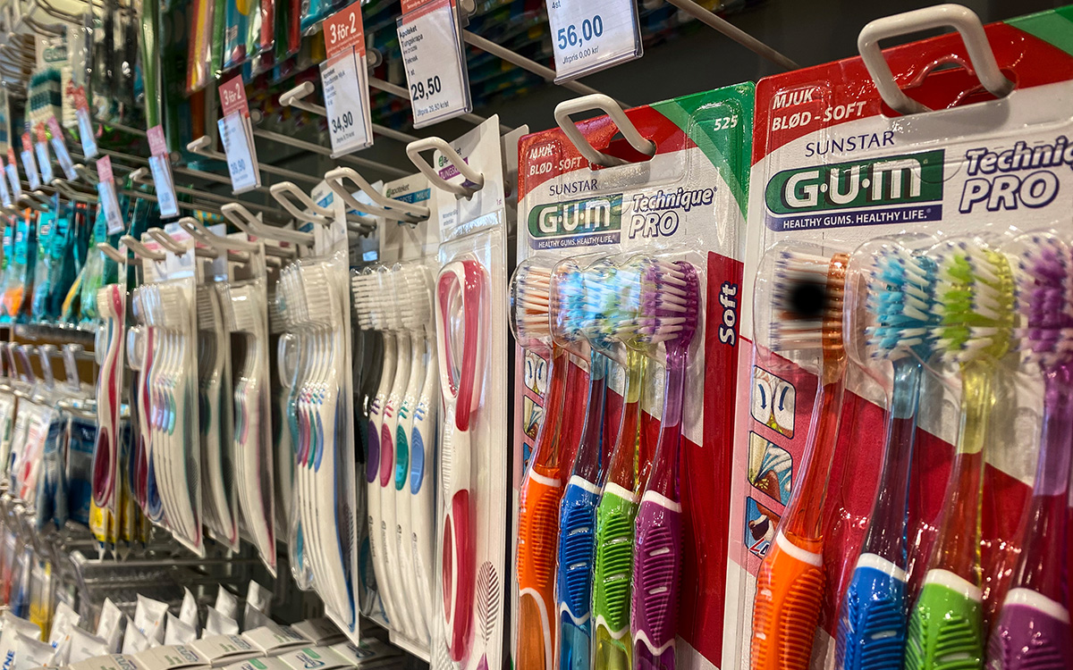 Tandborstar som hänger på rad i ett apotek.