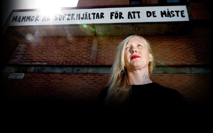 Gatukonstnären Jessica Hallbäck framför ett av sina verk