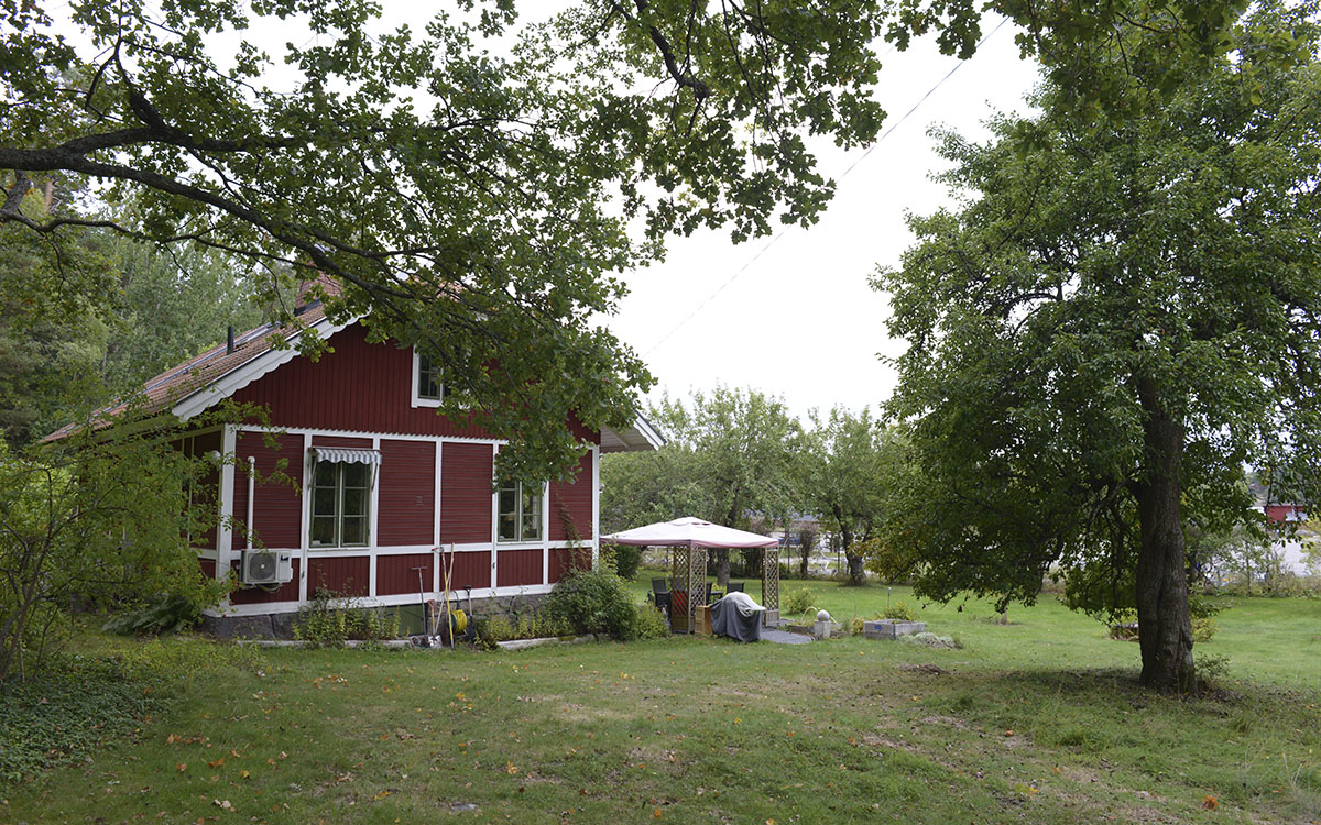 Rött gammalt hus med stor trädgård