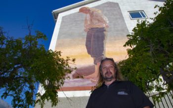 Bovärden Jörgen Karlsson framför en väggmålning av Linus Lundin, även känd under namnet Yash.