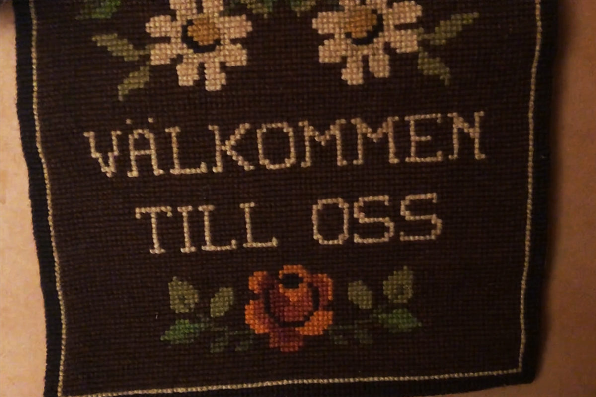 Broderi med texten: Välkommen till oss.