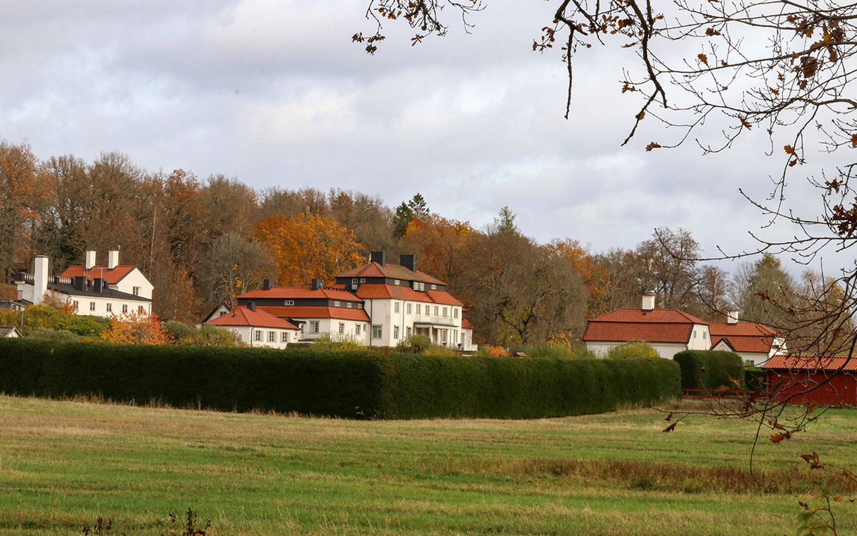 Bild tagen på avstånd av Harpsund. I förgrunden syns ett fält, bakom syns den vita herrgården och flera av dess byggnader.