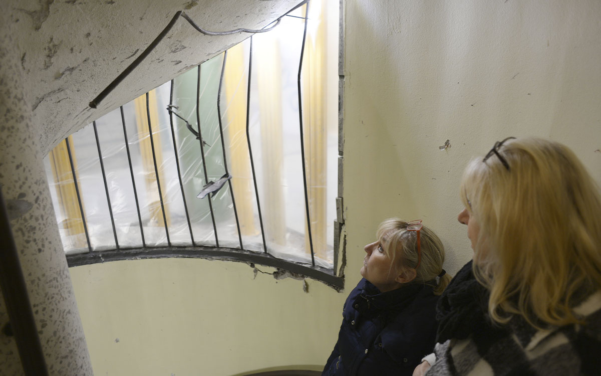 två kvinnor som inspekterar trapphus efter detonation