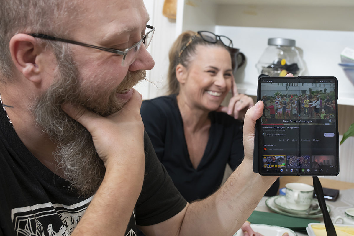 Daniel Carlenfors och Linda Danielsson tittar på musikvideon de var med och spelade in mot Stena Fastigheters renoveringsplaner på Pennygången i Göteborg