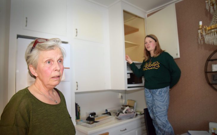 En kvinna i övre 50-årsåldern i förgrunden och en yngre kvinna i bakgrunden. Bilden är tagen i ett kök.