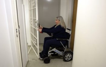 Kvinna försöker ta sig in genom en tung gallergrind