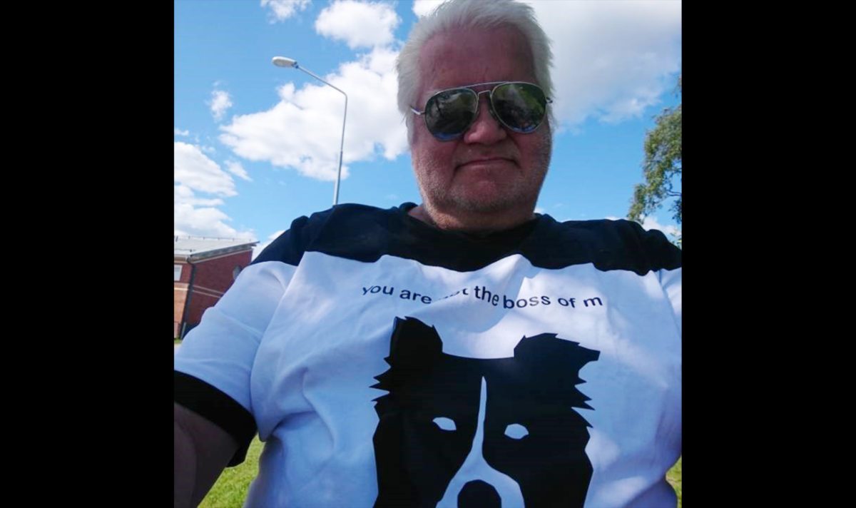 En man i 70-årsåldern med t-shirt och solglasögon.