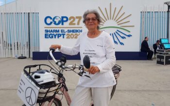 Dorothee Hildebrandt med sin cykel i Sharm el-Sheik. Bakom hennes syns en skylt med texten Cop 27, vilket var namnet på FN:s klimatkonferens i den egyptiska turistorten.