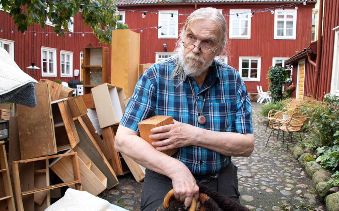 Kenneth Jälkhammar står på gården framför tomma bokhyllor.