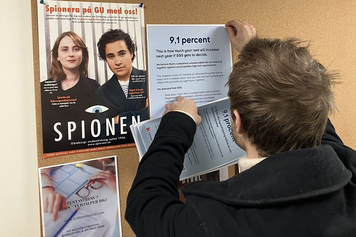 Andrzej Cahlenstein sätter upp affischer på både svenska och engelska där många studenter rör sig.