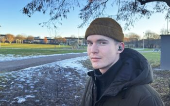 Porträtt på Emil Jansson i beige mössa och svart jacka. I bakgrunden en park med fotbollsmål och fläckvis snö och is i gräset. Uppsalahems hyresyrkande är historiskt högt i år.