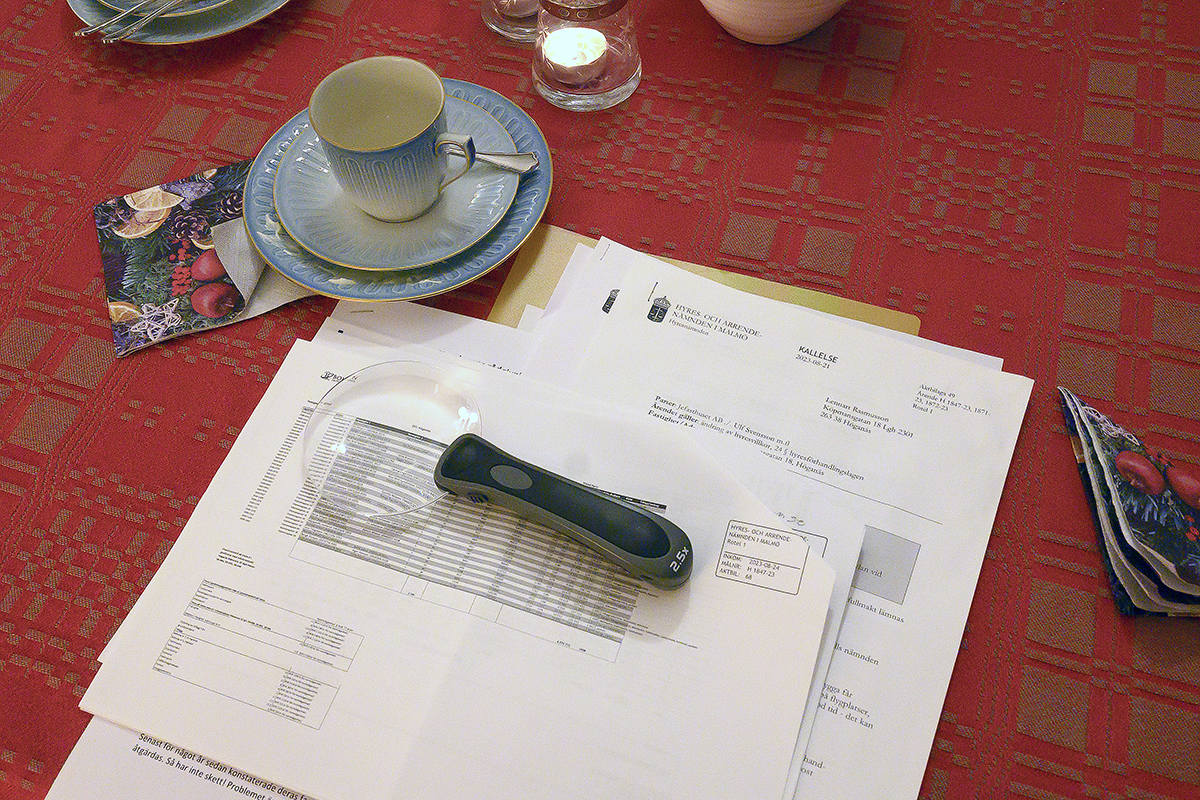 Papper och ett förstoringsglas på ett bord.