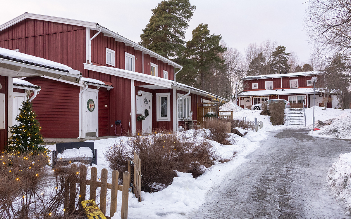 Rött trähus med vita knutar i två våningar vid en snöig och isig väg. Hyresgäster hos AB-hem riktar kritik mot brister i lägenheterna och eftersatt underhåll.