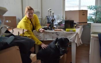 Marjo Kiviluoma sitter med sin hund i lägenheten som räddningstjänsten dömde ut. Nu har hon blivit hemlös.