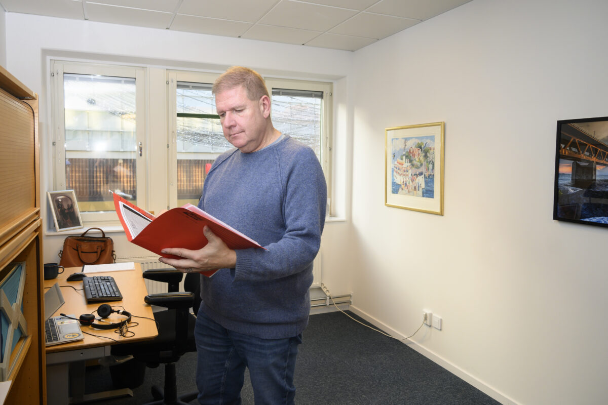 En man undersöker mappar på kontoret.