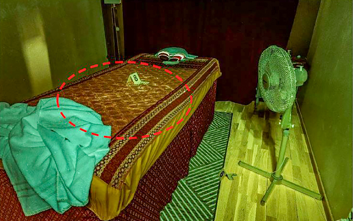 Bild inifrån ett massagerum på en thaisalong, där en säng syns. På bilden har polisen ritat in en röd ring, vilket markerar en besudling av sperma som man hittade på sängen vid en brottsplatsundersökning.