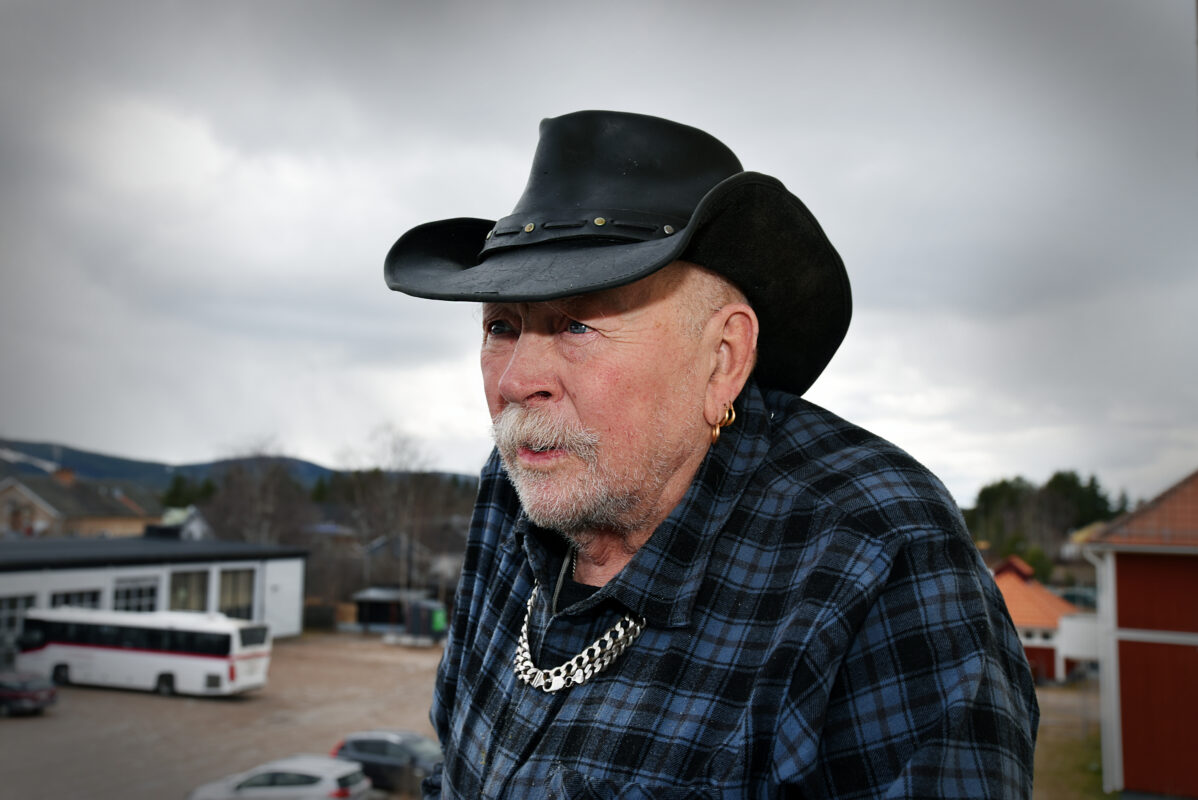 Äldre man i cowboyhatt på balkong.