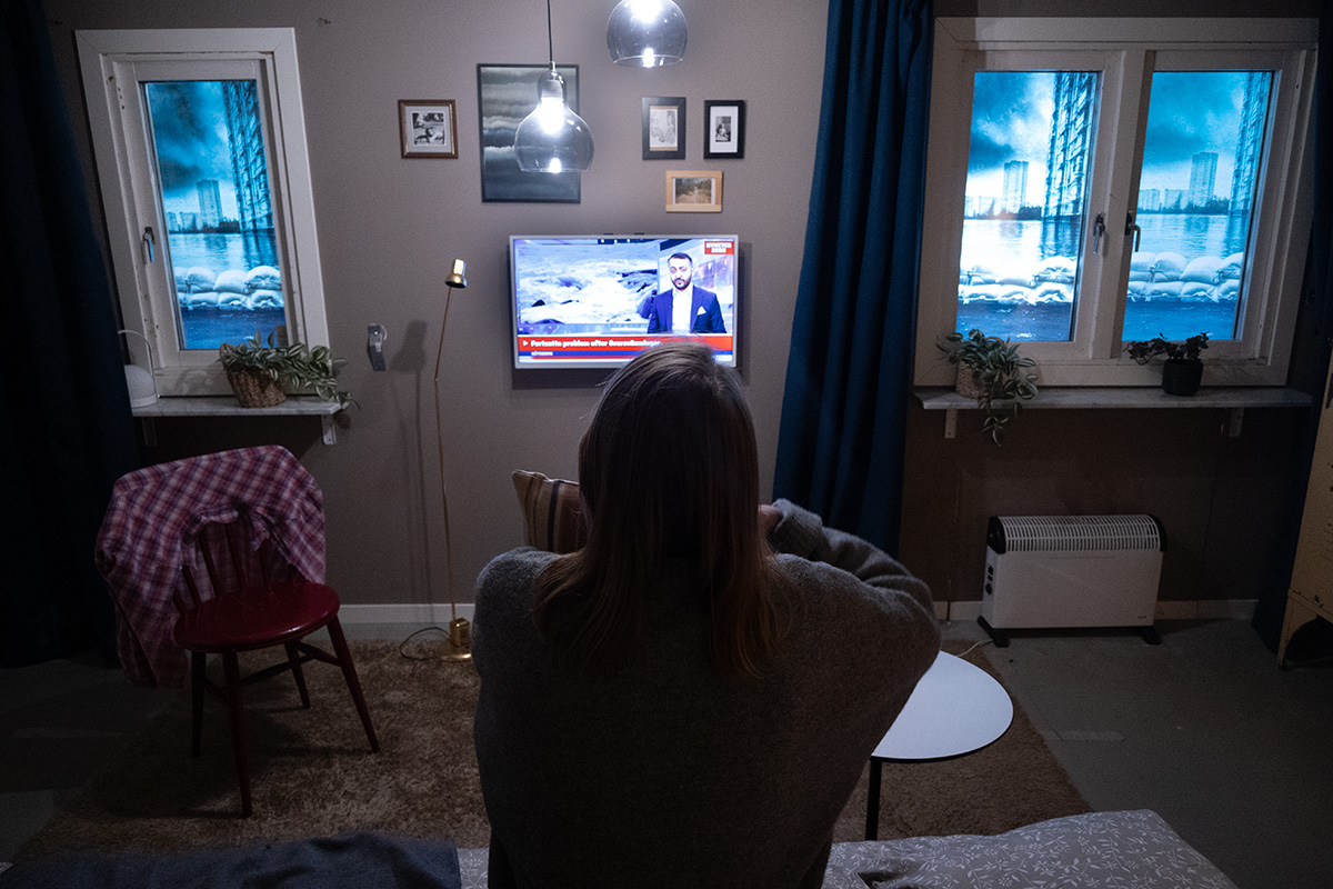 En kvinna, sedd bakifrån, tittar på tv.