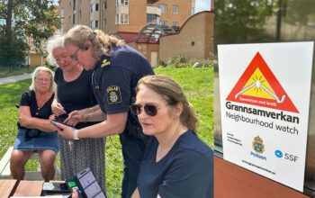 Polisen Anna Schelin visar boende i HRF Rättartunet hur de kan göra olika inställningar i appen för Grannsamverkan.