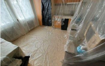 Stora delar av lägenheten har täckts av plast, vilket bedöms ha bidragit till fukt- och mögelproblemen. Bilden kommer från saneringsföretaget Belfors rapport.