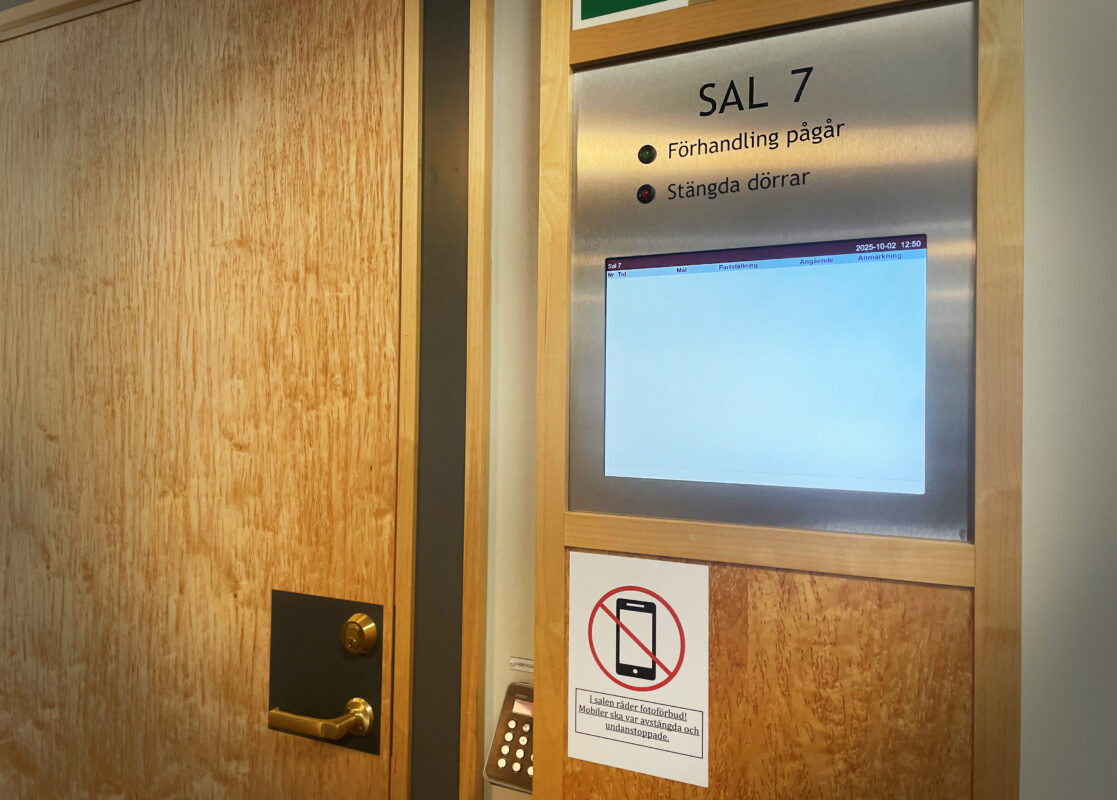 En stängd dörr med informationstavla utanför om pågående mål.