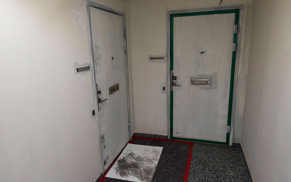 Ett trapphus där brandskadade och sotiga lägenhetsdörrar målats över.